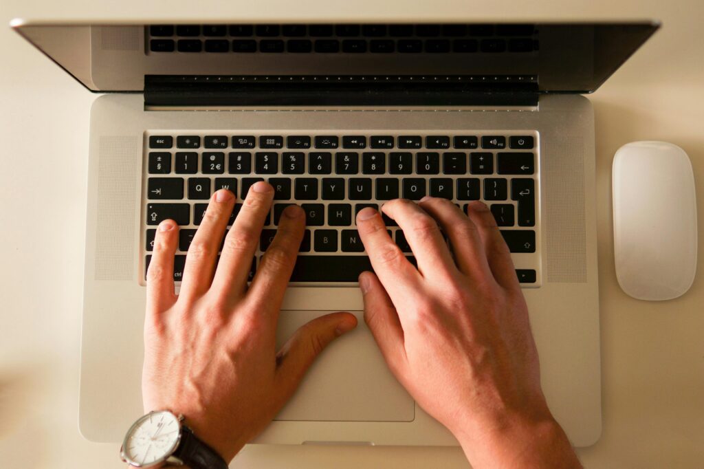 Hands in a typing position on a laptop keyboard