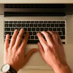 Hands in a typing position on a laptop keyboard